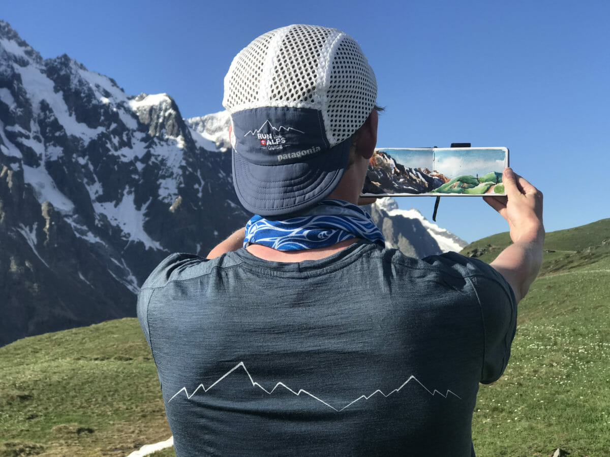 Max Romey wearing RTA gear and holding a painting above Bertone hut near Courmayeur, Ital. (Photo: Jordyn Milbrath)