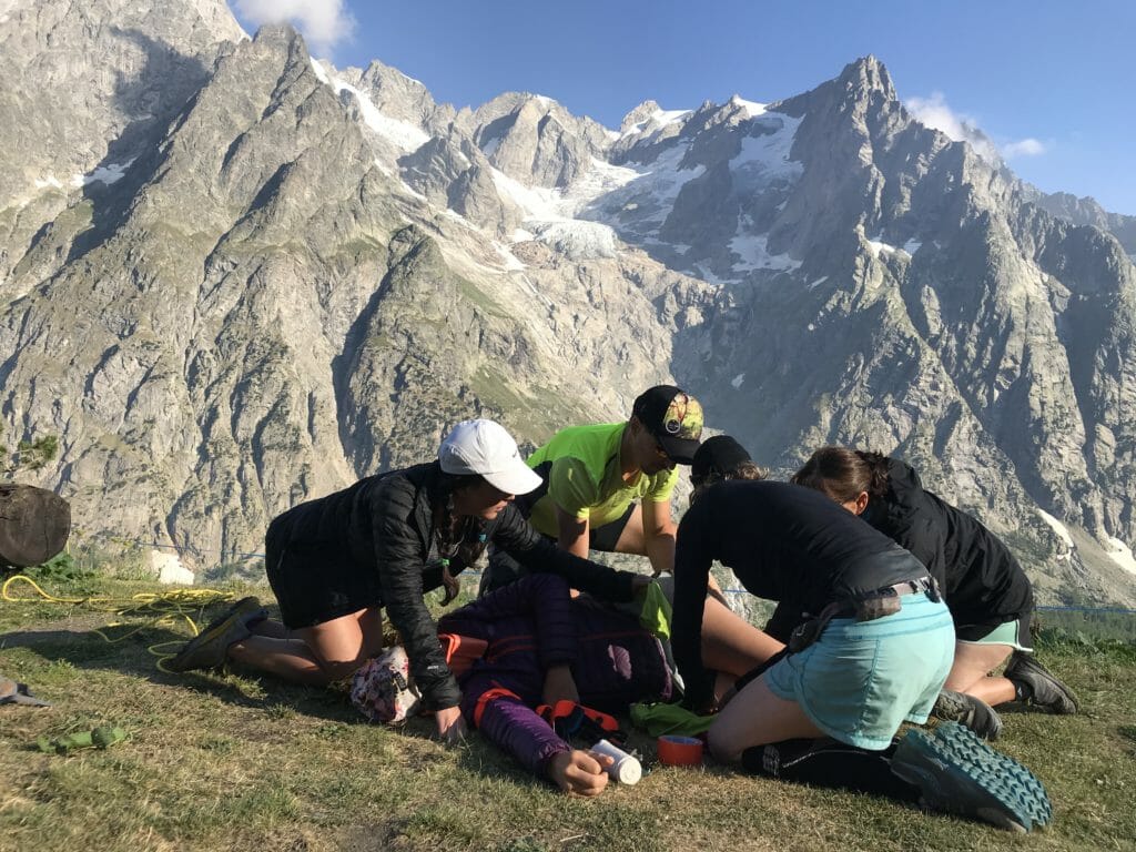 A team of volunteers surround an injured person in a training drill in the Alps.