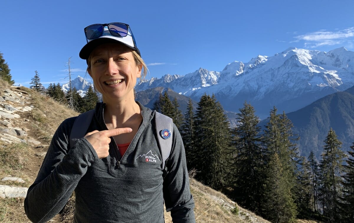 Run the Alps Guide Emily Geldard with her IML badge in front of the Mont Blanc massif