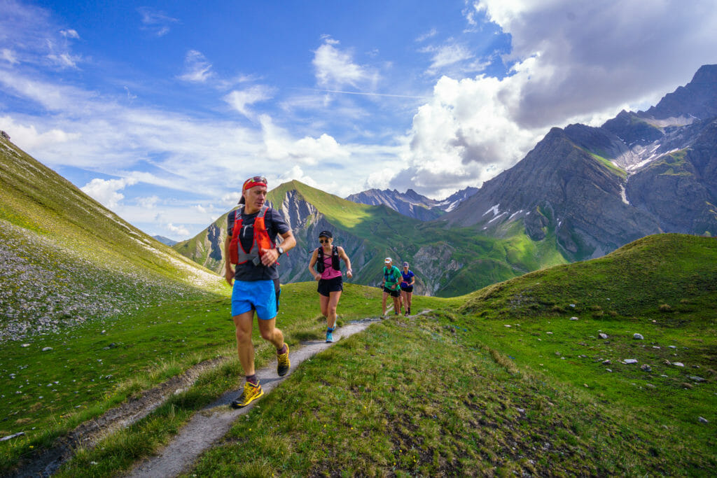 Run the Alps Guide Giles Ruck running above treeline with a group