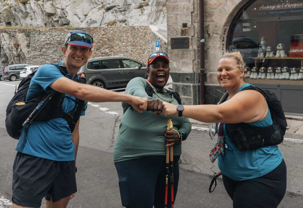 Mirna Valerio celebrating getting to the top of the Swiss Alps pass with two Run the Alps team members